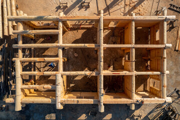 Canvas Print - Construction industry concept. Timber wooden frame of house from bar, foundations of villas. Aerial top view