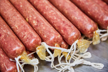 Wall Mural - Factory for the production of meat products, boiled sausages. Traditional spicy sausage, ready to dry, lies on the table. The concept of handmade meat products. Sophistication.