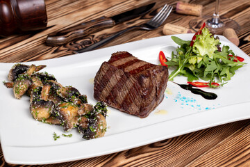 Sticker - grilled Denver steak with grilled mushrooms on white plate