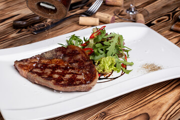 Sticker - juicy Ribeye steak with vegetables on white plate