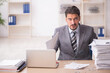 © Elnur - Young male employee unhappy with excessive work in the office