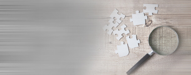 a magnifying glass and puzzle pieces on the table