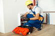 © Kostiantyn - Focused technician, plumber in uniform using tools from toolbox while setting hot water pipes in apartment