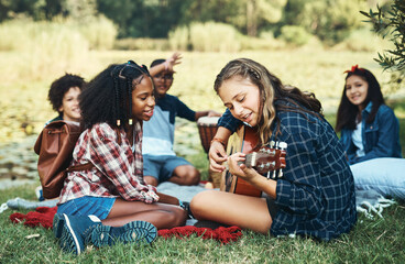 what's summer camp without a singalong. shot of a group of teenagers playing musical instruments in 