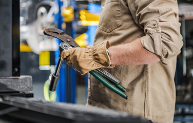 Wall Mural - Automotive Industry Worker with Car Repairing Tools in His Hands