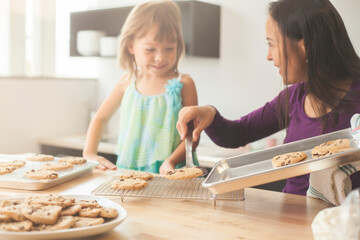 Mother and daughter baking cookies in a bright kitchen