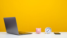 Laptop And Desk Graphic Designer White There Is A Pink Pig And A Black Phone. A Businessman's Desk That Is Ready To Work From Home. Yellow Background