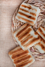 Traditional South African Braai Bread Or Roosterbrood, Cooked On Open Flame With Rustic Style Background