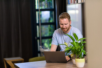 Wall Mural - Portrait of casual pensive puzzled man using computer looking at laptop at home office having solving problems calling customer support video call online