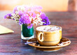 A purple bouquet and a cup of coffee on the table