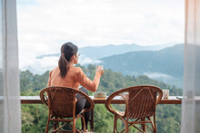Happy Woman Drinking Coffee And Eating Breakfast Against Mountain View At Countryside Home Or Homestay In The Morning. Vacation, Blogger, SoloTravel, Journey, Trip And Relaxing Concept