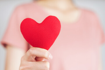 Wall Mural - Woman holding red heart, love, health insurance, donation, happy charity volunteer, world mental health day, world heart day, valentine's day