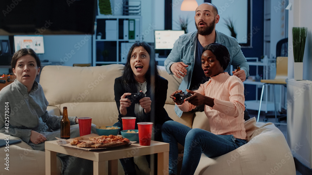 Gamen Workmate Multi ethnic workmates winning video games on console with controllers ...