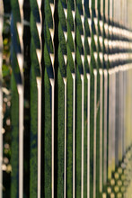 An Old Metal Green Fence In Perspective