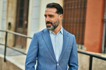 Wall Mural - Middle age businessman smiling happy standing at the city.