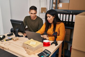 Sticker - Young woman and man working at small business ecommerce scared and amazed with open mouth for surprise, disbelief face