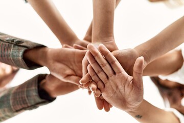 Group of young businesswoman standing with hands together at the office.