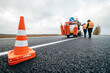 Workers applying new road markings, outside the city