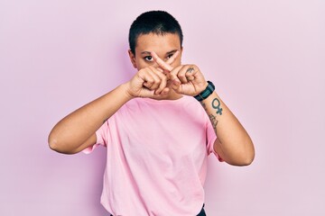 Sticker - Beautiful hispanic woman with short hair wearing casual pink t shirt rejection expression crossing fingers doing negative sign