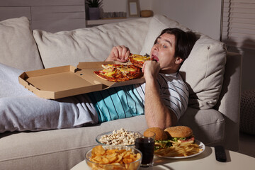 Sticker - Overweight man eating pizza on sofa at home