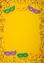 Mardi Gras Gold Color Beads With Masquerade Festival Carnival Masks And Golden, Green, Purple Confetti On Yellow Background.