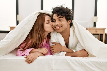 Sticker - Young couple covering with bedsheet lying on the bed at bedroom.