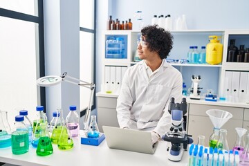 Sticker - Young hispanic man wearing scientist uniform using laptop at laboratory