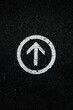 white directional arrow on a black floor