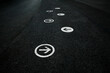 White directional arrows painted on a black floor