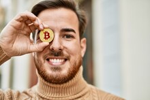 Young Caucasian Man Smiling Happy Holding Bitcoin Over Eye At The City.