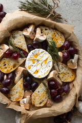 Wall Mural - dish with baked camembert with grapes, champignons, rosemary and garlic on the table