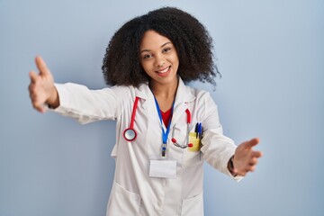 Poster - Young african american woman wearing doctor uniform and stethoscope looking at the camera smiling with open arms for hug. cheerful expression embracing happiness.