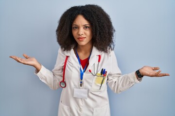 Wall Mural - Young african american woman wearing doctor uniform and stethoscope clueless and confused with open arms, no idea concept.