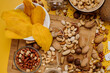 Mix of different types of dried nuts in compositions on a yellow background. Top view. Flat lay
