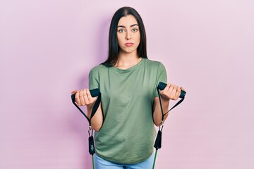 Canvas Print - Beautiful woman with blue eyes training arm resistance with elastic arm bands depressed and worry for distress, crying angry and afraid. sad expression.