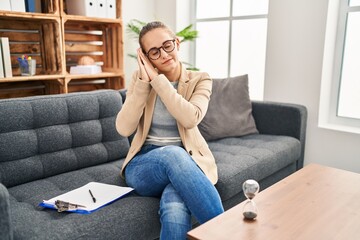 Canvas Print - Young woman working at consultation office sleeping tired dreaming and posing with hands together while smiling with closed eyes.