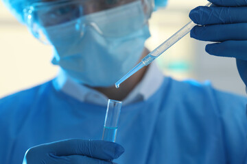 Poster - Scientist dripping sample into test tube in laboratory, closeup. Medical research