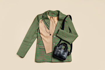 Wall Mural - Green classic jacket and beige women's top with bag. Women's stylish autumn or spring trendy clothes. Fashion concept. Flat lay, top view.