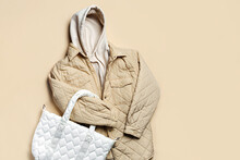 Jacket,  White Hoody With Quilted Bag  On Beige Background. Fashion Sweatshirt, Casual Youth Style, Sports. Stylish Autumn Or Spring  Clothes.