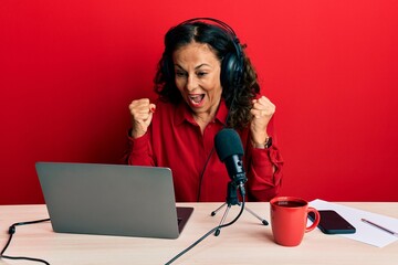 Sticker - Beautiful middle age woman working at radio studio celebrating surprised and amazed for success with arms raised and open eyes. winner concept.