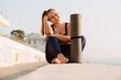 © Drobot Dean - Young ginger woman smiling during yoga practice at seafront