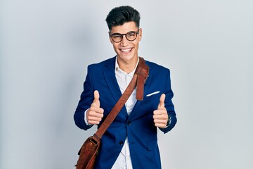 Sticker - Young hispanic man wearing business clothes success sign doing positive gesture with hand, thumbs up smiling and happy. cheerful expression and winner gesture.