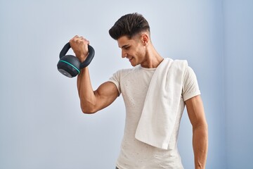 Canvas Print - Young hispanic man smiling confident training using kettlebell at sport center