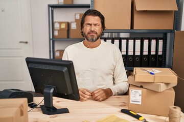 Canvas Print - Handsome middle age man working at small business ecommerce skeptic and nervous, frowning upset because of problem. negative person.