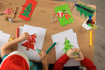 Wall Mural - Little children making beautiful Christmas greeting cards at table, top view