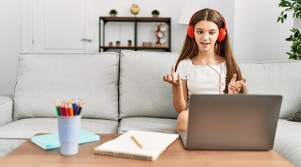 Canvas Print - Adorable girl having online class sitting on sofa at home