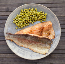 Appetizing baked trout fillets with green peas