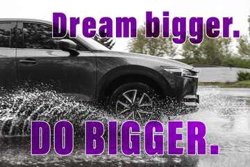 Dream Bigger Do Bigger. Inspirational quote motivating to set life goals freely and forget about reasons that can hold back. Text against luxury car outdoors
