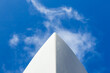 The bow of a white yacht, against a blue sky with white clouds. View from below.