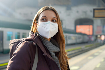 Wall Mural - Portrait of casual woman waiting train with KN95 FFP2 protective mask at train station on winter